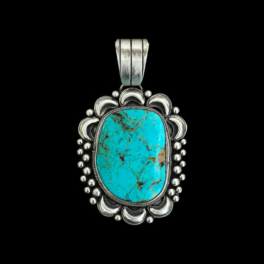 Turquoise pendant with silver frame on black background