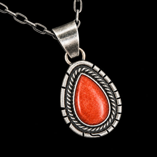 Silver pendant with a red spiny oyster stone on a black background