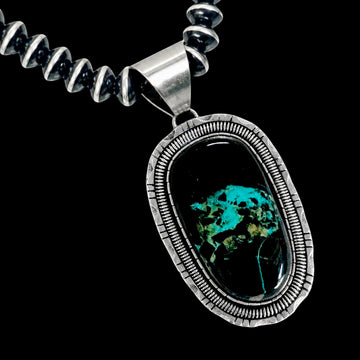 Necklace with a silver pendant featuring blackjack stone on a black background